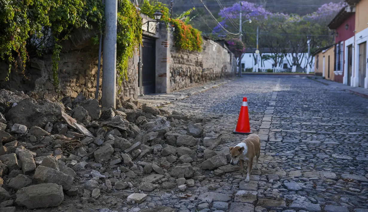 Batu memenuhi jalan setelah sebagian dinding rumah runtuh, dipicu oleh dipicu gempa bumi berkekuatan 6,2 skala Richter semalam di Antigua, Guatemala, 16 Februari 2022. Gempa tersebut menyebabkan tanah longsor di jalan, kerusakan rumah dan pemadaman listrik. (AP Photo/Santiago Billy)