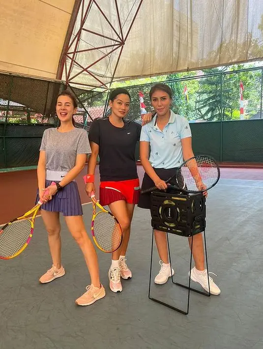 Bermain tenis bersama sahabat, Astrid Tiar tampil feminin sporty dengan crew neck abu-abu dan rok tenis beraksen lipit berwarna navy. Untuk sentuhan girly, Astrid Tiar mengenakan sneakers berwarna pink. (instagram/astridtiar127)
