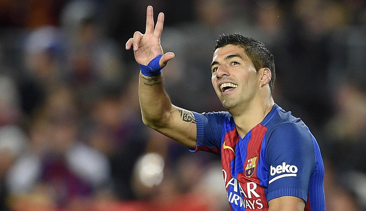 Striker Barcelona, Luis Suarez, merayakan gol yang dicetaknya ke gawang Sporting. Kemenangan ini membuat La Blaugrana menggeser Real Madrid di puncak klasemen Liga Spanyol. (AFP/Lluis Gene)