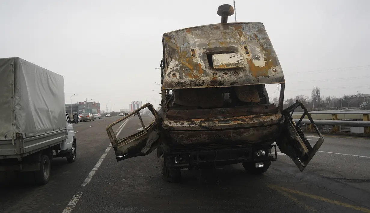 Sebuah truk militer, yang terbakar saat bentrokan, terlihat di sebuah jalan di Almaty, Kazakhstan, Minggu  (9/1/2022). Pihak berwenang telah mendapatkan kembali kendali atas gedung-gedung administrasi. (Vladimir Tretyakov/NUR.KZ via AP)