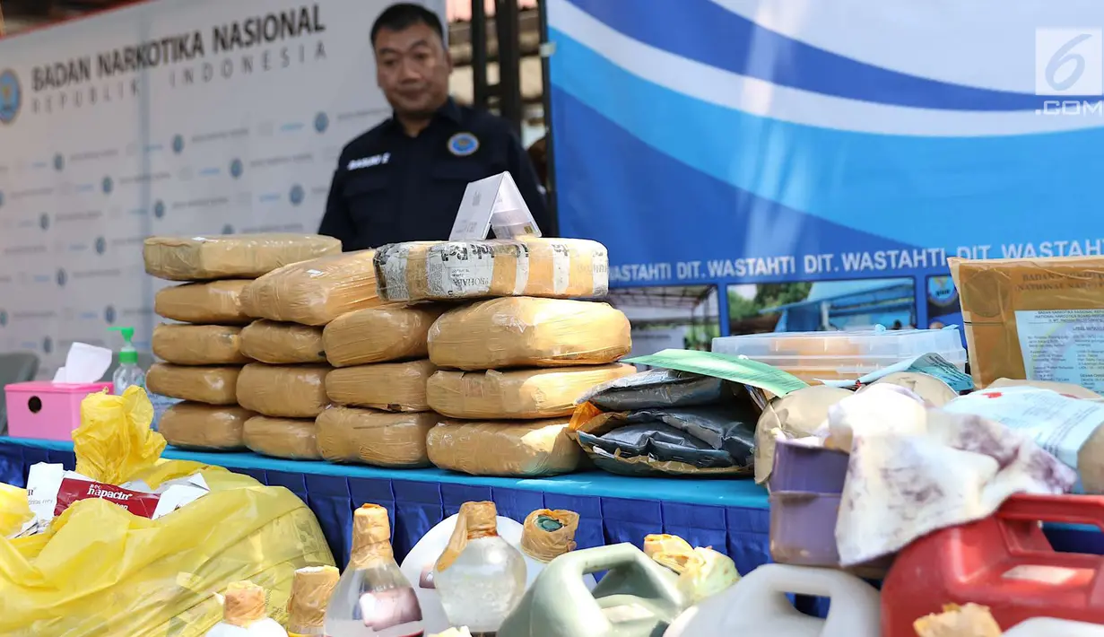 Petugas Badan Narkotika Nasional (BNN) menunjukkan barang bukti kasus narkotika di Gedung BNN, Jakarta, Jumat (7/9). BNN juga memusnahkan 6.122 gram prekursor serbuk dan 201.760,80 gram ganja. (Liputan6.com/Immanuel Antonius)