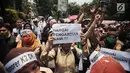 Pegawai honorer DKI Jakarta mengangkat kertas bertuliskan aspirasi saat menggelar demo di Balai Kota, Jakarta, Rabu (26/9). Massa mengenakan seragam pramuka dan membawa sejumlah poster aspirasi. (Liputan6.com/Faizal Fanani)