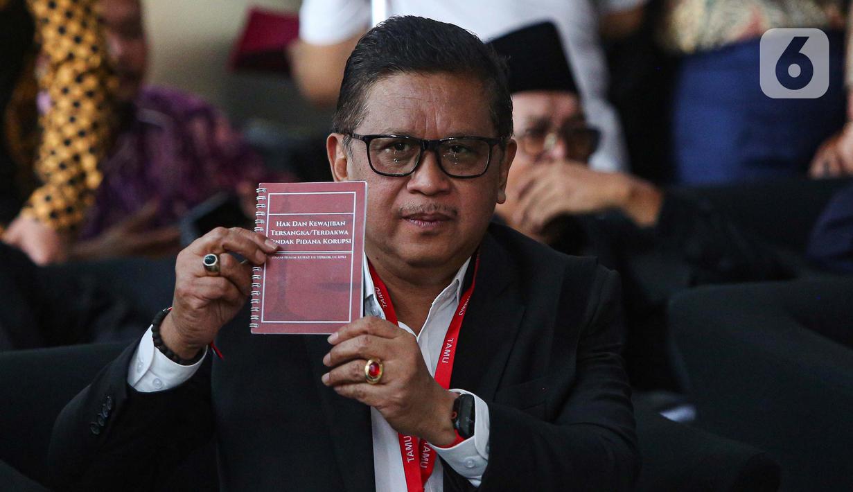 Tersangka kasus dugaan suap pergantian antarwaktu (PAW) dan perintangan penyidikan, Hasto Kristiyanto menunjukkan buku tentang Hak dan Kewajiban Tersangka/Terdakwa Tindak Pidana Korupsi sesaat sebelum menjalani pemeriksaan oleh penyidik Komisi Pemberantasan Korupsi (KPK) di Gedung Merah Putih KPK, Jakarta, Senin (13/1/2025). (Liputan6.com/Angga Yuniar)
