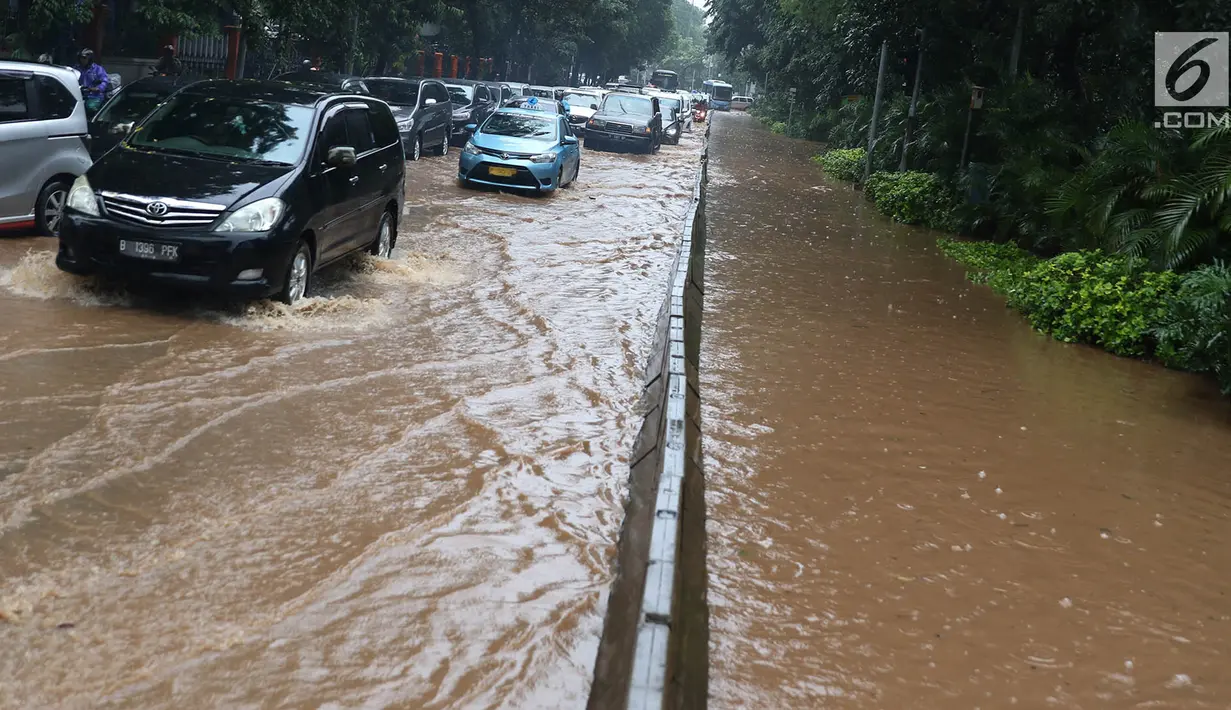 Sejumlah kendaraan melewati banjir yang merendam Jalan Lapangan Banteng Utara, Jakarta, Kamis (15/2). Hujan deras yang mengguyur dan buruknya drainase menyebabkan kawasan tersebut banjir hingga setinggi lutut orang dewasa. (Liputan6.com/Immanuel Antonius)