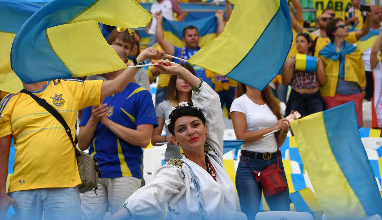 Suporter Ukraine menari sambil mengibarkan bendera sebelum laga  Euro 2016  Ukraina melawan Polandia di Stadion Velodrome, Marseille, Rabu (22/6/2016) dini hari WIB. (AFP/Anne-Christine  Poujoulat)