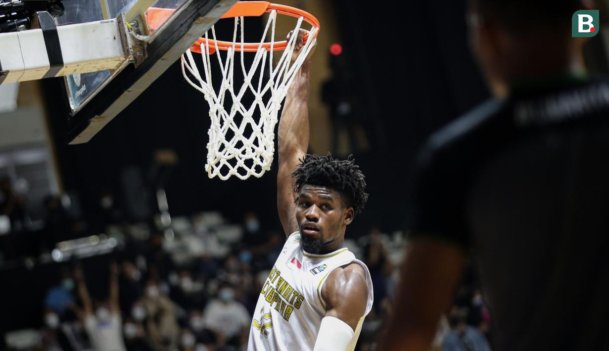 Pemain West Bandits Combiphar Solo, D. Harris bergantung di ring usai mencetak poin saat laga pekan pertama IBL Tokopedia 2022 melawan Rans PIK Basketball di Hall Basket Gelora Bung Karno, Senayan, Sabtu (15/01/2022). (Bola.com/Bagaskara Lazuardi)