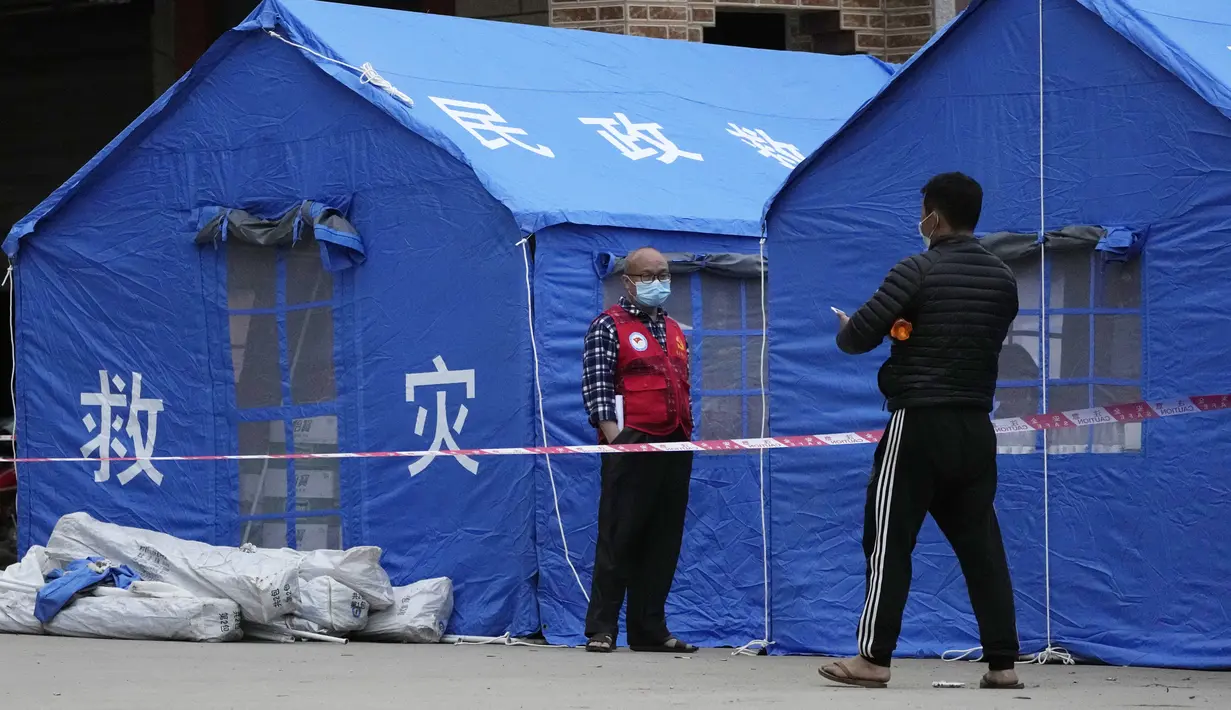 Tenda bertuliskan "Disaster rescue" didirikan di pintu masuk desa Lu yang mengarah ke lokasi jatuhnya pesawat China Eastern di Guangxi, Selasa (23/3/2022). Kecelakaan pesawat dengan 132 orang di dalamnya itu memicu api yang cukup besar dan terlihat pada citra satelit NASA. (AP Photo/Ng Han Guan)