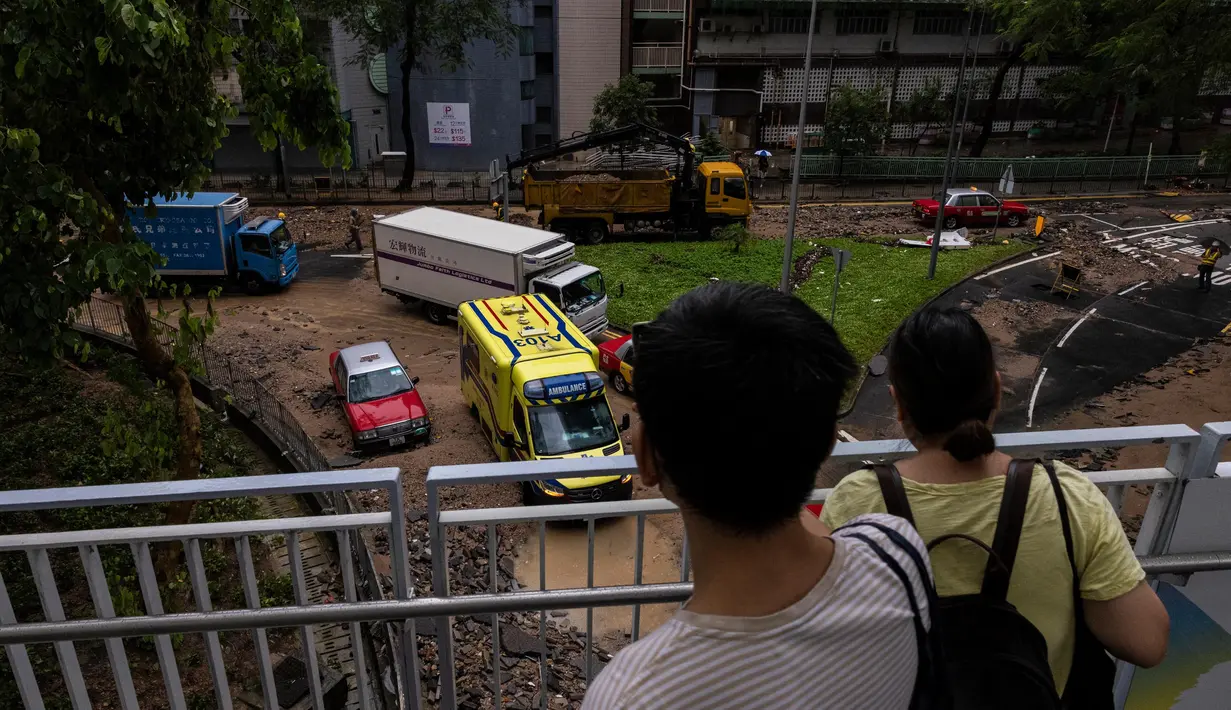 Observatorium cuaca Hong Kong mencatat curah hujan yang turun mencapai 158,1 milimeter per jam. Warga mengambil foto jalan yang tergenang air setelah hujan deras di Hong Kong, Jumat, 8 September 2023. (AP Photo/Louise Delmotte)