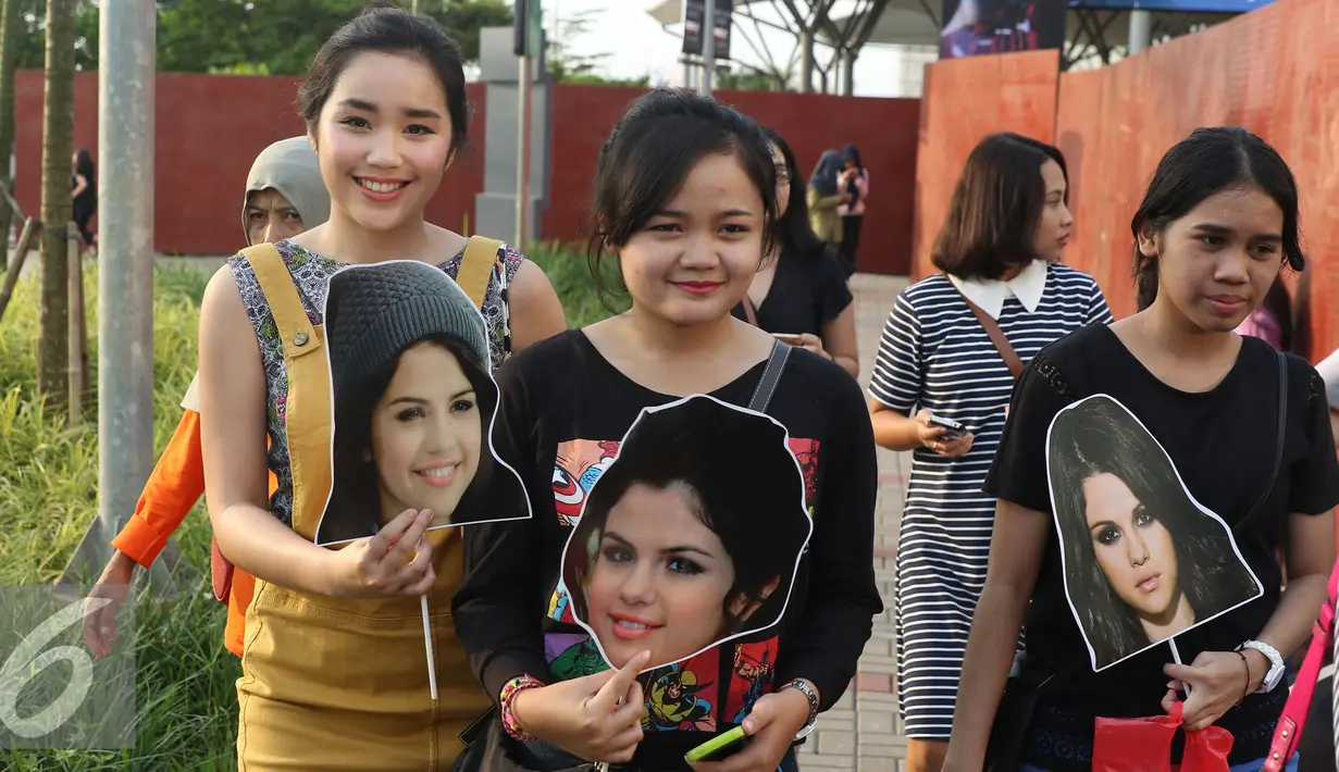 Sejumlah penggemar membawa poster muka Selena Gomez sebelum menyaksikan konser di ICE BSD CITY, Tanggerang, (23/7). Selena Gomez menggelar konser yang bertajuk "REVIVAL TOUR" di ICE BSD CITY yang akan di mulai jam 20.00. (Liputan6.com/Herman Zakharia)