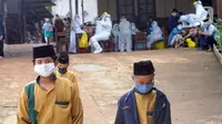 Para santri antre melakukan swab test di Pondok Pesantren Baitul Hikmah, Bojongsari, Depok, Jawa Barat, Kamis (12/11/2020). Swab test massal dilakukan menyusul ditemukannya paparan COVID-19 terhadap seorang santri dan untuk memutus mata rantai penyebaran. (merdeka.com/Arie Basuki)