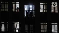Pasien COVID-19 terlihat pada jendela salah satu kamar isolasi Rumah Sakit Darurat Wisma Atlet Kemayoran, Jakarta, Selasa (19/1/2021). Pemprov DKI Jakarta mengungkapkan ketersediaan tempat tidur isolasi dan ICU di rumah sakit rujukan COVID-19 tersisa 13 persen. (merdeka.com/Iqbal S. Nugroho)