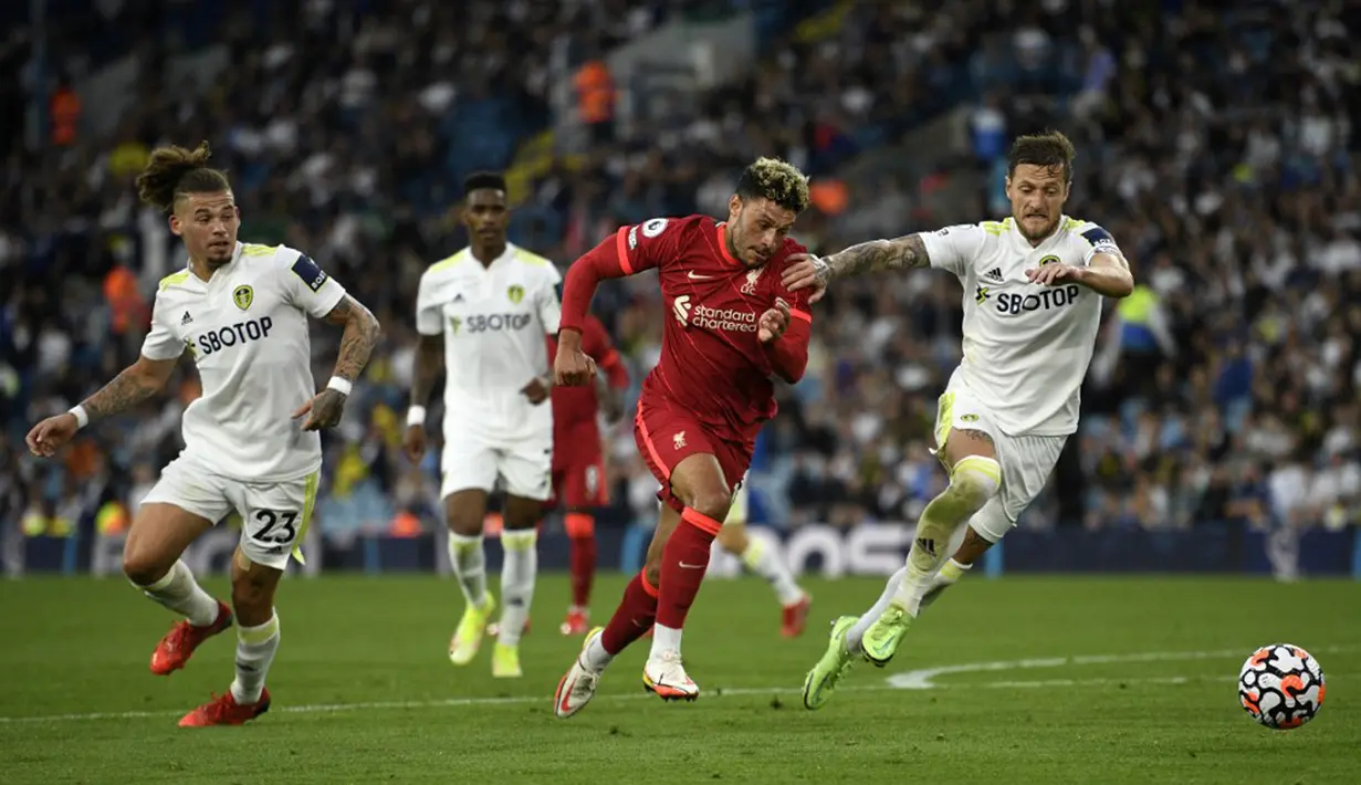Pemain Liverpool Alex Oxlade-Chamberlain (tengah) berebut bola dengan pemain Leeds United Liam Cooper (kanan) pada pertandingan Liga Inggris di Elland Road, Leeds, Inggris, 12 September 2021. Liverpool menang 3-0. (Oli SCARFF/AFP)
