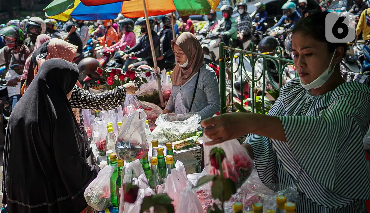 Penjual bunga tabur melayani pembeli di TPU Karet Tengsin, Jakarta, Minggu (27/3/2022). Sebagian warga memanfaatkan waktu jelang Ramadan menjadi penjual bunga tabur musiman untuk memenuhi kebutuhan ziarah ke makam yang dijual Rp 5.000 - Rp 20.000 per kantong plastik. (Liputan6.com/Faizal Fanani)