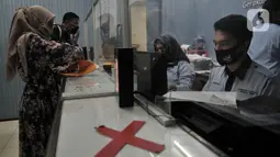 Suasana pelayanan di Kantor Suku Dinas Dukcapil Jakarta Timur, Senin (15/6/2020). Layanan tatap muka Dukcapil Jakarta Timur yang kembali dibuka sejak Jumat (12/6) lalu disambut antusias warga yang ingin mengurus dokumen administrasi kependudukan. (merdeka.com/ Iqbal S Nugroho)