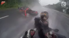 Pengendara sepeda motor terjatuh saat melaju di sebuah jalanan yang sedang dilanda hujan deras. Salah satu pengendara berusaha melindungi sang kekasih yang juga ikut terjatuh.