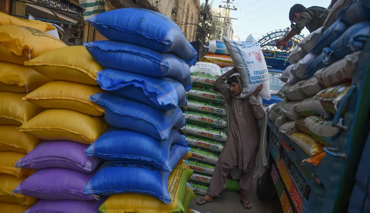 Seorang buruh Pakistan menurunkan karung beras di pasar grosir di Karachi (8/4). Karachi adalah kota pelabuhan. Walikotanya saat ini dijabat oleh Syed Mustafa Kamal. AFP Photo/Rizwan Tabassum)