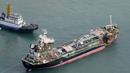 Pemandangan udara dari helikopter Jiji Press menunjukkan sebuah kapal tanker minyak ditarik setelah bertabrakan dengan jembatan yang menghubungkan ke Bandara Internasional Kansai di kota Izumisano, prefektur Osaka (5/9). (AFP Photo/Jiji Press)