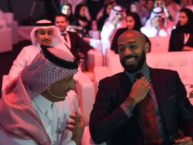 Mantan pemain Arsenal, Thierry Henry (tengah) merapihkan dasi saat menghadiri konferensi Quality of Life Program 2020 di ibukota Saudi Riyadh (3/5). Program ini adalah salah satu program realisasi visi Arab Saudi 2030. (AFP Photo/Fayez Nureldine)