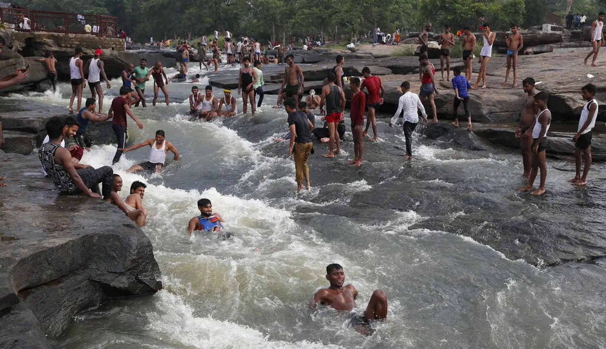 Orang-orang bermain di perairan Air Terjun Rajdari pada hari musim panas yang terik di distrik Chandauli, negara bagian Uttar Pradesh, India (28/6/2021).  Air Terjun Rajdari adalah tempat piknik yang populer bagi orang-orang di sekitar area tersebut pada musim panas. (AP Photo/Rajesh Kumar Singh)