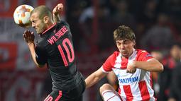 Aksi pemain Arsenal, Jack Wilshere (kiri) berebut bola dengan pemain Belgrade Crvena Zvezda, Filip Stojkovic pada laga grup H Liga europa di Stadion Rajko Mitic, (19/10/2017). Arsenal menang 1-0. (AFP/Andrej Isakovic)