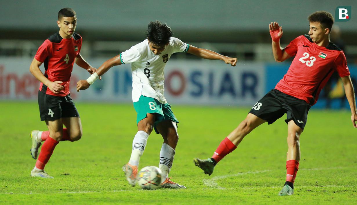 <p>Pemain Timnas Indonesia U-17, Arkhan Kaka melepaskan tendangan yang berusaha diblok pemain Palestina, Baraa Rabei pada laga Grup B Kualifikasi Piala Asia U-17 2023 antara Timnas Indonesia menghadapi Palestina di Stadion Pakansari, Bogor, Jumat (7/10/2022). (Bola.com/M Iqbal Ichsan)</p>