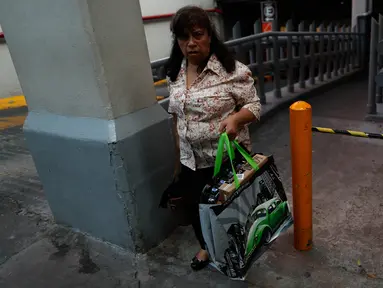 Seorang perempuan membawa tas yang dapat digunakan kembali yang baru dibeli saat meninggalkan toko grosir di Mexico City, 1 Januari 2020. Toko-toko berhenti menyediakan kantong plastik sekali pakai kepada pelanggan sesuai undang-undang yang berlaku di ibu kota Meksiko. (AP/Rebecca Blackwell)