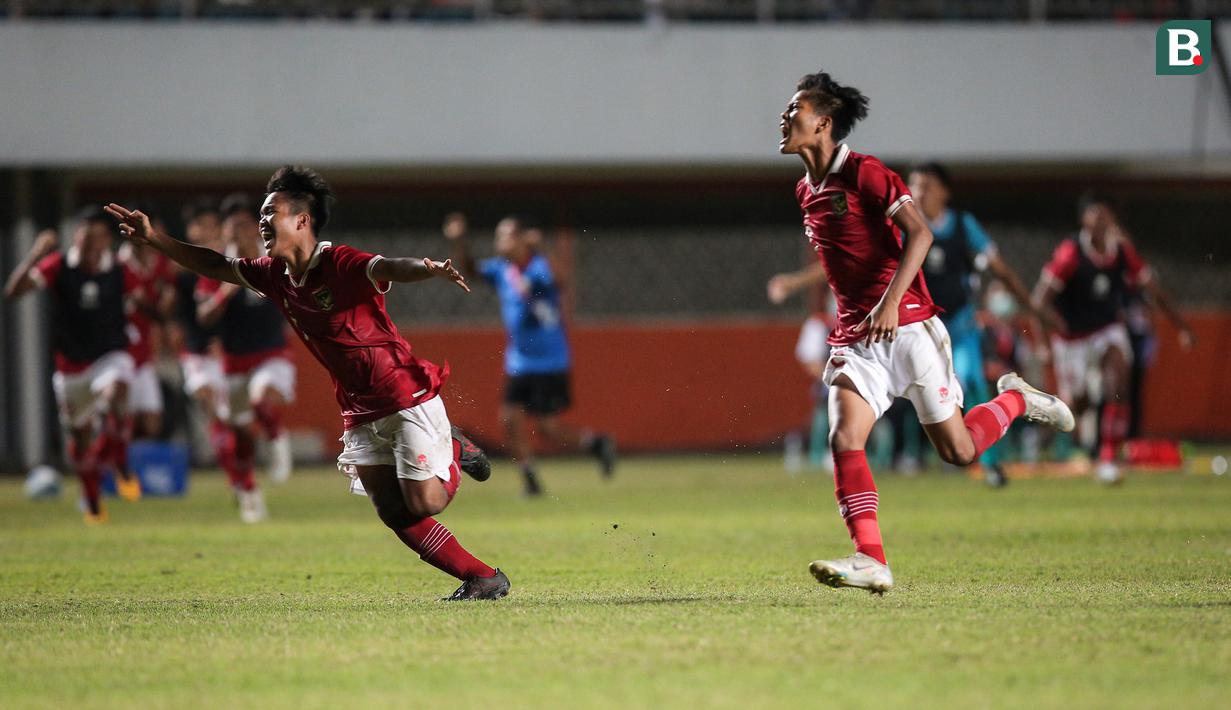 Muhammad Ridho Ikhsan (kiri) dan Rizdjar Nurviat Subagja berlari ke arah Muhammad Nabil Asyura sebagai penendang terakhir Timnas Indonesia U-16 yang mampu membobol gawang Myanmar dalam drama adu penalti. (Bola.com/Bagaskara Lazuardi)