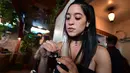 Erika Soto memegang alat oleskan dari Puffco sehari sebelum pembukaan resminya di Lowell Cafe di Hollywood Barat, California  (30/9/2019). Kafe ganja pertama di Amerika telah dibuka di Hollywood Barat. (AFP Photo/Frederic J. Brown)