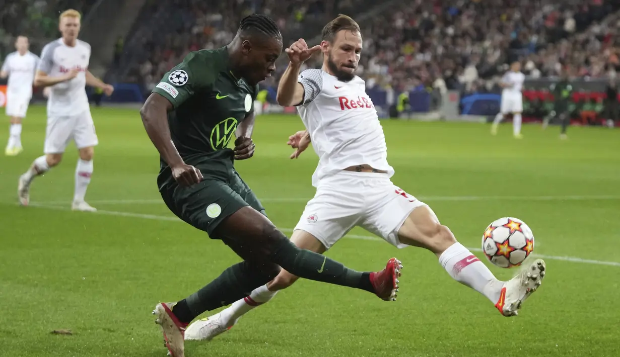 Gelandang Wolfsburg , Ridle Baku berusaha mengumpan bola dari kawalan pemain RB Salzburg, Andreas Ulmer pada pertandingan Grup G Liga Champions di stadion Salzburg, Austria, Rabu (20/10/2021). Salzburg menang atas Wolfsburg 3-1. (AP Photo/Matthias Schrader)