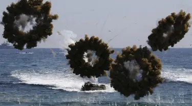 Kendaraan tempur amfibi mengeluarkan bom asap selama latihan militer Korea Selatan dan Amerika Serikat di Pohang , Korea Selatan, (12/3). Latihan tersebut diikuti 300 ribu pasukan Korsel dan sekitar 17 ribu pasukan Amerika. (REUTERS / Kim Hong - Ji)