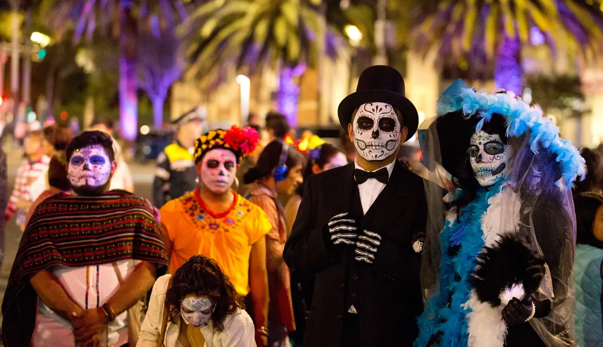 Peserta mengenakan kostum mirip figur terkenal Catrina selama Prosesi Grand Catrinas, bagian dari perayaan Day of The Dead, di Mexico City, Minggu (22/10). Banyak orang yang mengenakan kostum dan hiasan tengkorak memenuhi jalanan. (AP/Rebecca Blackwell)