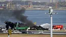 Tabrakan malam itu menyebabkan bola api dan asap hitam muncul di bawah pesawat Japan Airlines saat melaju di landasan pacu setelah menabrak pesawat penjaga pantai di landasan. (Kyodo News via AP)