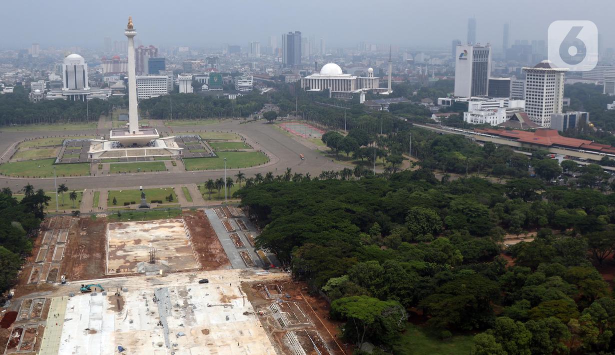 Aktivitas pengerjaan proyek revitalisasi Taman Sisi Selatan Monumen Nasional dilihat dari ketinggian, Jakarta, Minggu (19/1/2020). Proses revitalisasi dimulai dengan penebangan ratusan pohon di taman selatan Monas dan menjadikan kawasan tersebut terlihat gersang. (Liputan6.com/Helmi Fithriansyah)