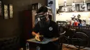 Pramusaji menggunakan pelindung wajah, masker dan sarung tangan saat melayani pelanggan di The Atjeh Connection Coffee and Resto, Jakarta, Senin (8/6/2020). Tempat ini siap menerapkan protokol kesehatan dalam menerapkan tatanan kehidupan baru atau ‘new normal’. (Liputan6.com/Faizal Fanani)