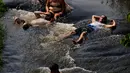 Orang-orang menyejukkan diri dari cuaca yang sangat terik di sungai saat gelombang panas di Paraguari, Paraguay, Minggu (16/1/2022). Suhu Paraguay secara umum mencapai 41 derajat celsius. (AP Photo/Jorge Saenz)