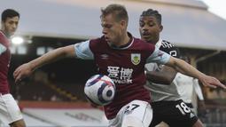 Striker Burnley, Matej Vydra (kiri) menguasai bola dibayangi gelandang Fulham, Mario Lemina dalam laga lanjutan Liga Inggris 2020/2021 pekan ke-35 di Craven Cottage Stadium, London, Senin (10/5/2021). Burnley menang 2-0 atas Fulham. (AP/Clive Rose/Pool)