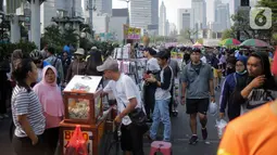 Pedagang kaki lima (PKL) berjualan di jalan saat car free day (CFD) di kawasan Bundaran HI, Jakarta, Minggu (6/10/2019). Kurangnya pengawasan petugas menyebabkan banyak PKL yang berjualan tidak pada tempat yang telah disediakan oleh Pemprov DKI Jakarta. (Liputan6.com/Faizal Fanani)