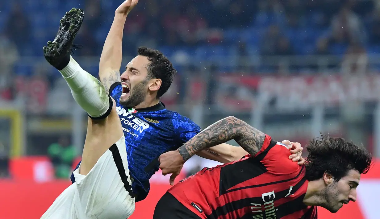 Pada menit kedelapan, wasit menunjuk titik putih dan memberikan hadiah penalti kepada Inter Milan usai Hakan Calhanoglu dilanggar oleh pemain AC Milan. (AFP/Tiziana Fabi)