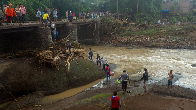 Tim SAR memperbaiki jembatan setelah tanah longsor melanda Gowa, Sulawesi Selatan, Jumat (25/1). Proses perbaikan terkendala cuaca buruk. (YUSUF WAHIL/AFP)