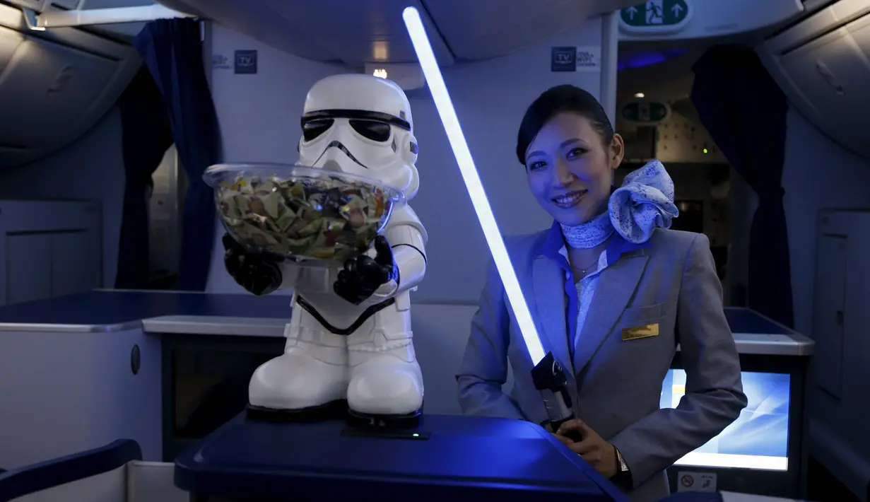 Seorang Pramugari menyapa pengunjung sambil memegang lightsabre atau pedang laser di pesawat Boeing 787 Dreamliner, Singapura, Kamis (12/11/2015).  Pesawat bertema Star Wars ini menjadi pertama di Asia Tenggara. (REUTERS/Edgar Su)