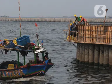 Pekerja menyelesaikan proyek tanggul pengaman pantai Kampung Nelayan Cilincing, Jakarta, Jumat (10/11/2023). (merdeka.com/Imam Buhori)