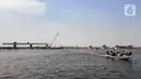 Kapal tradisional melintas dekat proyek pembangunan jembatan penghubung Dadap Tangerang-Pulau C di Kamal Muara, Penjaringan, Jakarta Utara, Minggu (17/11/2019). Pembangunan jembatan menyulitkan transportasi nelayan karena perairan menjadi sempit dan laut menjadi dangkal. (merdeka.com/Iqbal Nugroho)