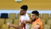 Pemain Olympiakos, Giorgos Masouras menyundul bola saat berduel dengan bek Wolverhampton Wanderers, Matt Doherty pada leg kedua babak 16 besar Liga Europa di Molineux Stadium, Kamis (6/8/2020). Wolverhampton menumbangkan Olympiakos dengan skor 1-0. (AP Photo/Rui Vieira)