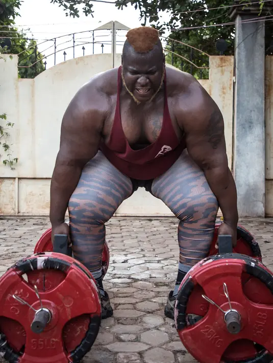 Iron Biby melakukan latihan di Bobo-Dioulasso, Burkina Faso pada 24 September 2018. Biby berlatih 4-5 jam sehari untuk menjaga kekuatannya, dia juga memiliki jalur sepanjang 46 meter di rumahnya untuk latihan menarik truk. (OLYMPIA DE MAISMONT / AFP)