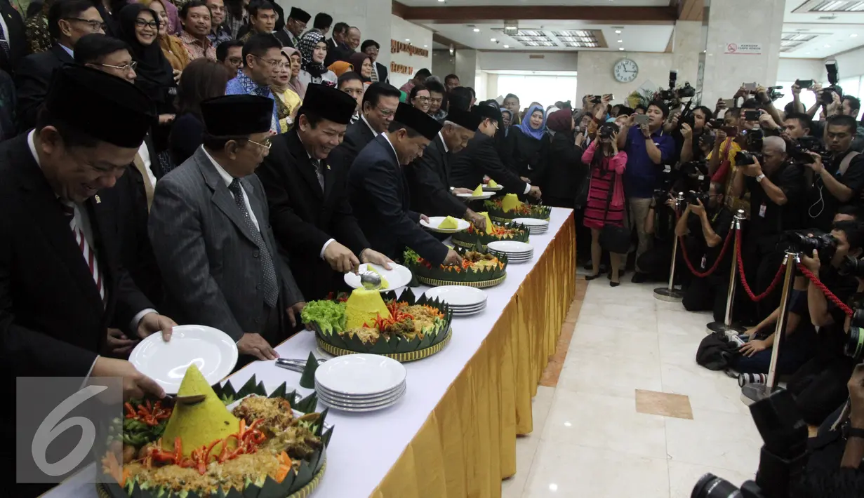 Ketua DPR, Ade Komarudin (tengah) bersama empat wakil Ketua DPR memotong tumpeng seusai menjalani Sidang Paripurna di Kompleks Senayan, Jakarta, Senin (29/8). Pemotongan tumpeng tersebut dalam rangka Hut ke-71 DPR. (Liputan6.com/Johan Tallo)