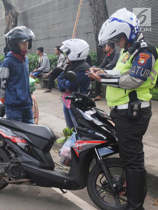 Anggota Satlantas Polres Tangerang Selatan memeriksa kelengkapan surat saat razia pajak kendaraan di Jalan BSD, Tangerang Selatan, Kamis (24/1). Razia juga untuk meningkatkan tertib lalu lintas dan disiplin pengendara bermotor. (Merdeka.com/Arie Basuki)