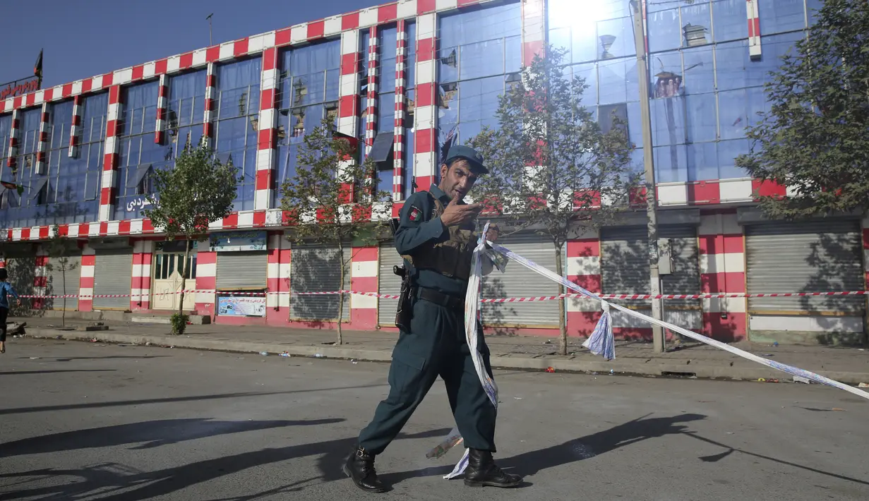 Seorang polisi Afghanistan berjaga di luar aula pernikahan yang rusak setelah ledakan di Kabul, Afghanistan, Minggu (18/8/2019). Hingga saat ini, belum ada kelompok yang mengklaim bertanggung jawab di balik serangan tersebut. (AP Photo/Rafiq Maqbool)