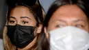 Leia Se, perempuan asal Rusia (kiri) menghadiri konferensi pers sebelum dideportasi di kantor Kemenkumham Bali, Rabu (5/5/2021). Leia Se diamankan pihak imigrasi karena membuat konten prank melukis wajah mirip masker di Bali akhirnya dideportasi. (AFP/Sonny Tumbelaka)