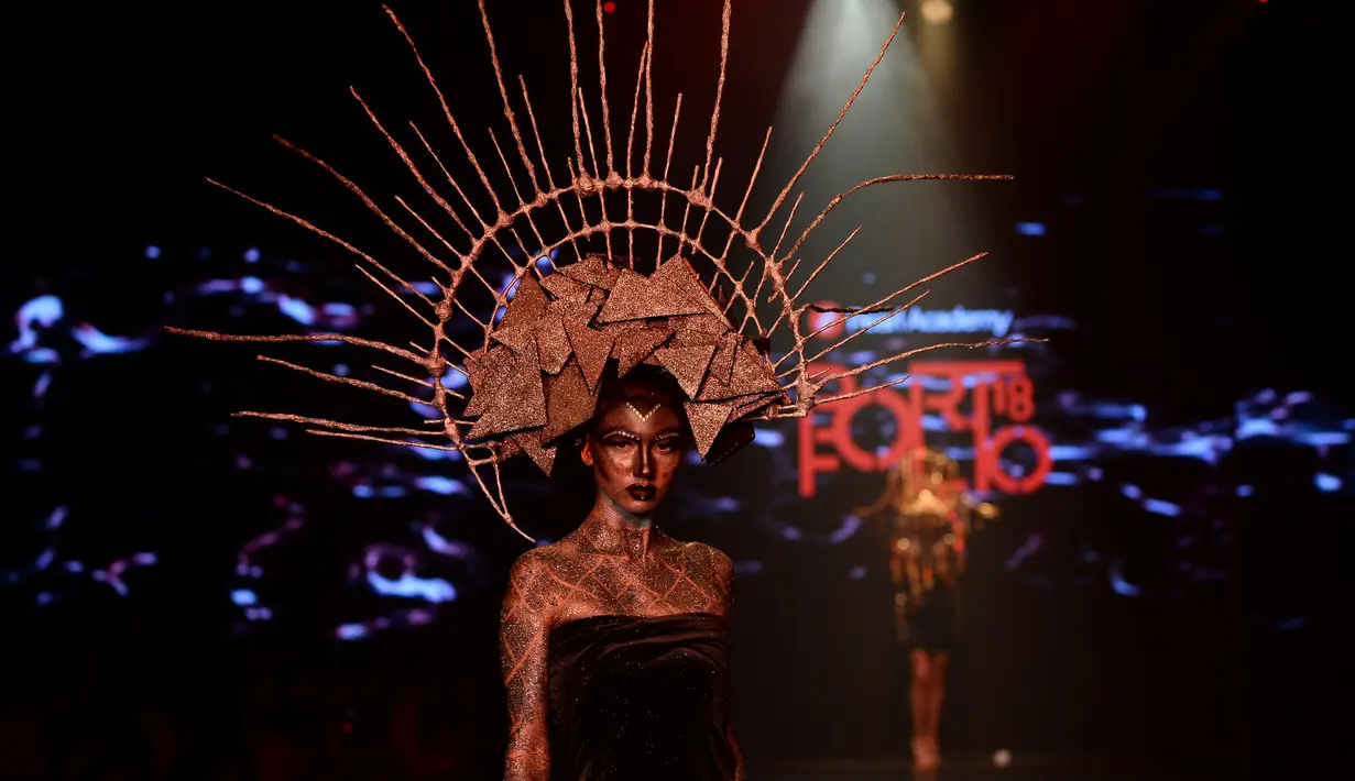 Seorang model membawakan karya busana perancang muda dari Pearl Academy di Autumn/Winter 2018 Fashion Week di New Delhi, India (18/3). (AFP Photo/Sajjad Hussain)