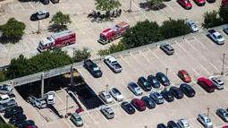 Mobil pemadam kebakaran berada di lokasi tempat parkir dua lantai yang runtuh di Irving, Texas, Selasa (31/7). Setidaknya lebih dari 20 mobil ada saat kejadian tersebut. (Ashley Landis/The Dallas Morning News via AP)